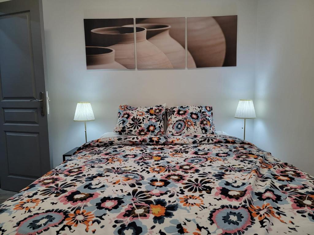 SoigniesLes gîtes du Ravel的一间卧室配有一张带五颜六色棉被的床
