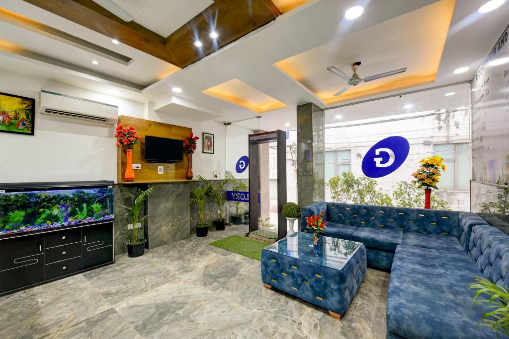 新德里Hotel Grand Qubic Near Delhi Airport的客厅设有蓝色的沙发和鱼缸
