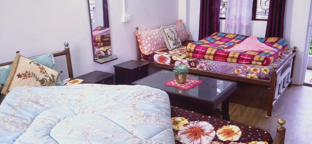 KurseongShriya Homestay的客厅配有床和桌子