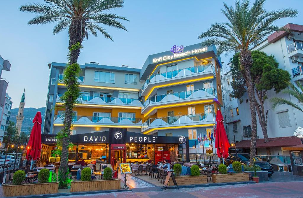 阿拉尼亚Arsi Enfi City Beach Hotel的一座楼前有棕榈树的酒店