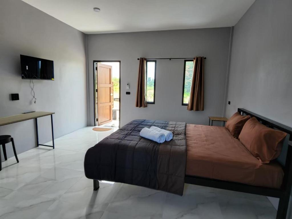 Ban Khao Khayai (1)เช็คอินรีสอร์ทชัยนาท Check-in resort的一间卧室配有一张大床和一张书桌
