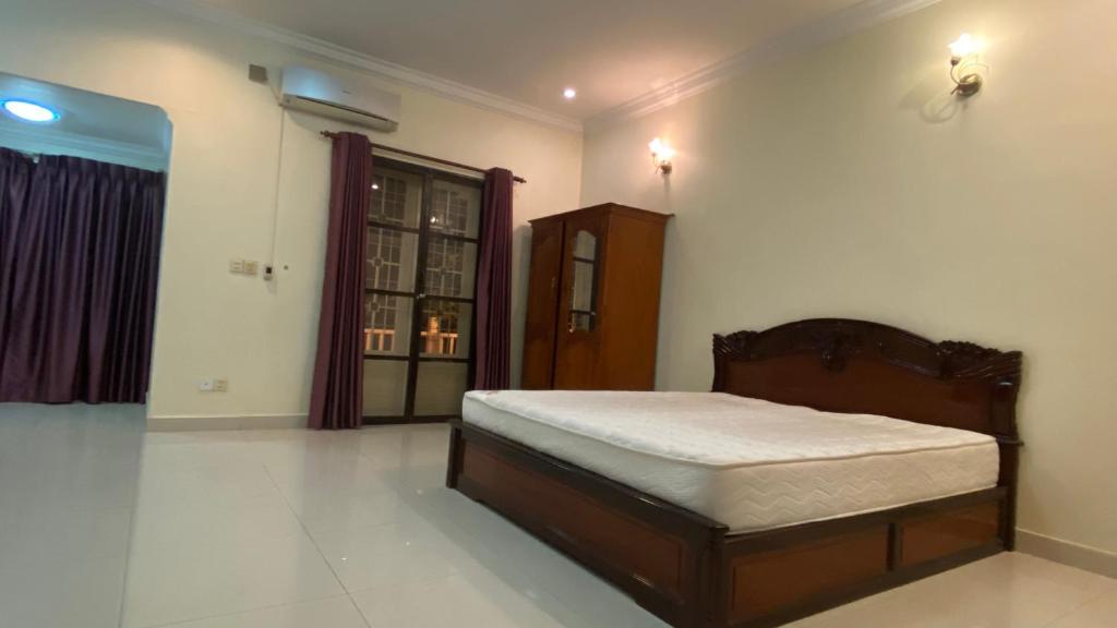 金边Entire Town House in Chroy Changva area的卧室位于客房的角落,配有一张床