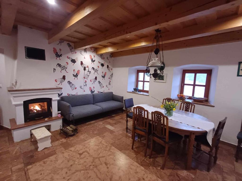 MonoszlóTik hegyi ház的客厅配有桌子、沙发和壁炉