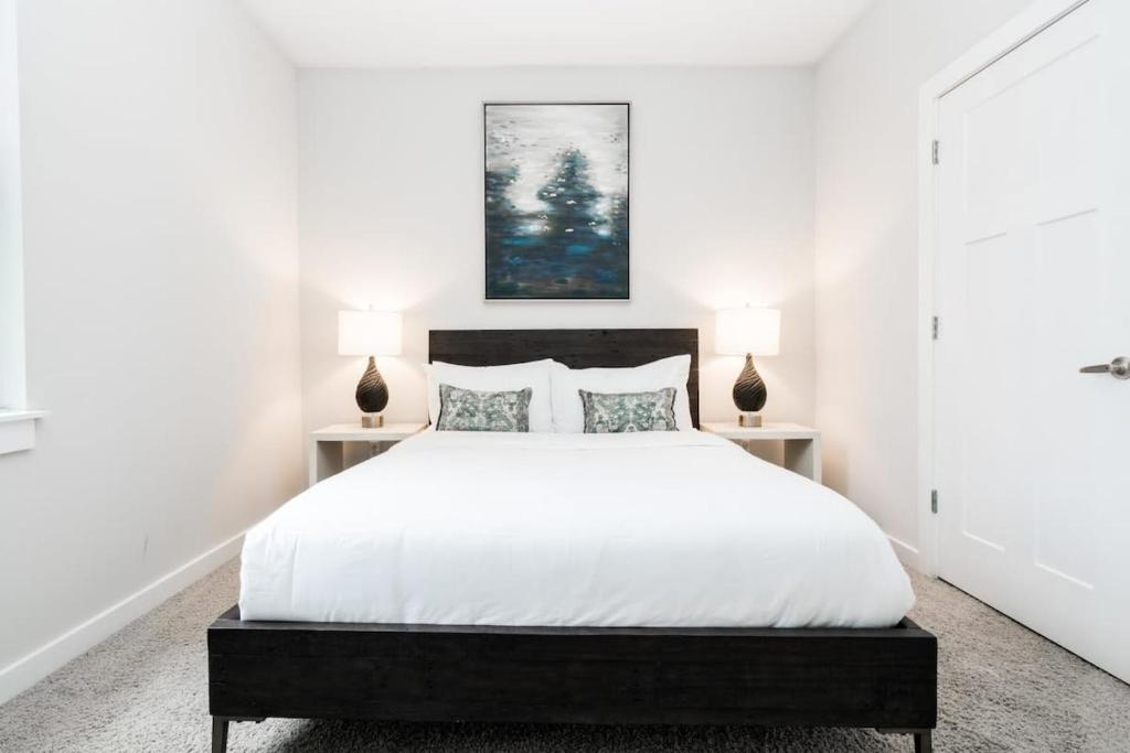 纳什维尔CozySuites Music Row Stunning 2BR -free parking 05的一间卧室配有一张带两盏灯的大型白色床。