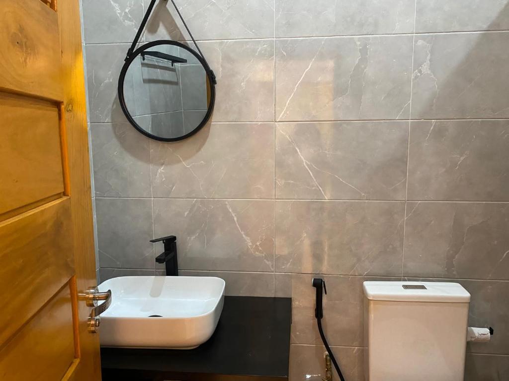 科托努Residence SIRTAK的一间带水槽、镜子和卫生间的浴室