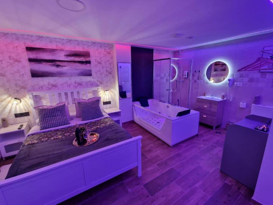 普拉多德尔雷sensual sierra love的紫色卧室设有一张大床和一个浴缸