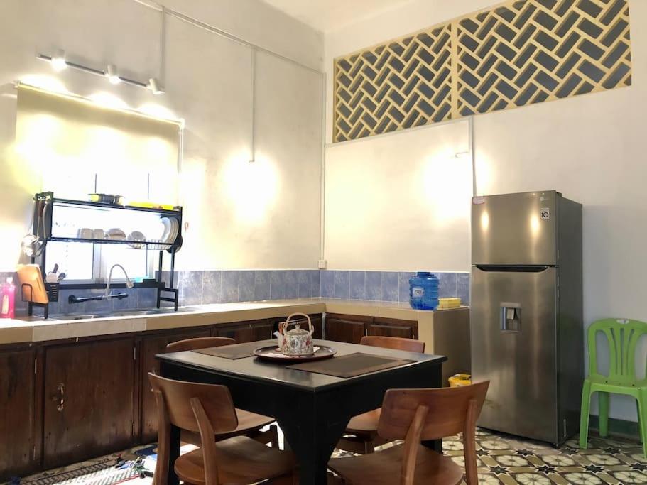 贡布Villa Garden Apart & swimming pool的厨房配有桌子和不锈钢冰箱。