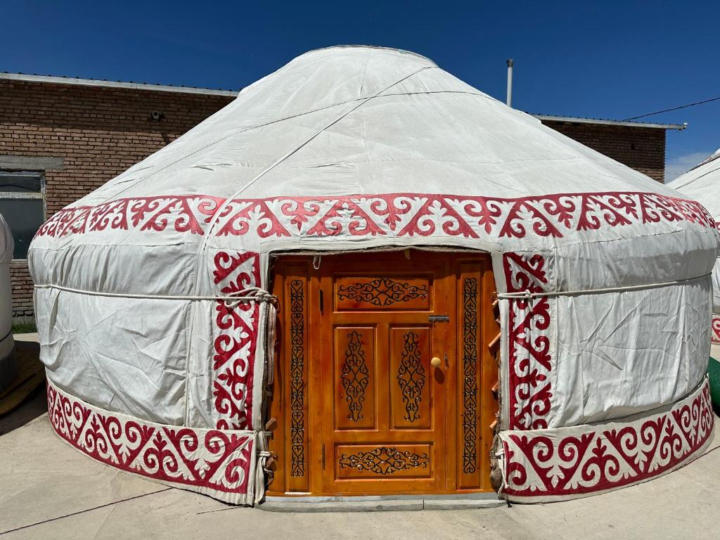 奥尔吉Traditional Yurts - Ulgii Guest House的红色和白色的蒙古包,设有木门