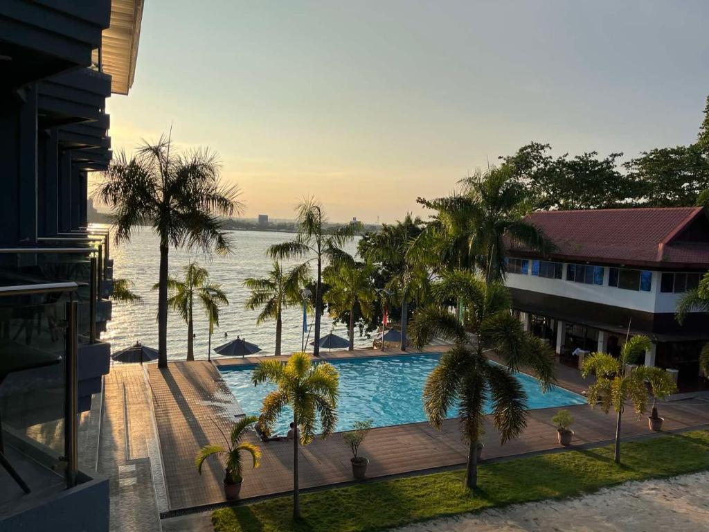 MagamomoSamal Sands and Shores的一座棕榈树游泳池,位于酒店大楼旁
