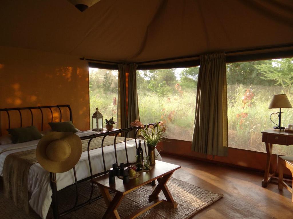 MauaIkweta Safari Camp的一间卧室设有一张床和一个大窗户