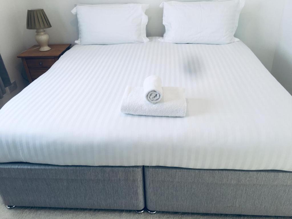 伯恩茅斯Jessjoe的一张白色的床,上面有一条可移动的毛巾