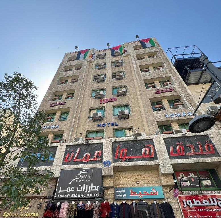 安曼Downtown Hawaa Amman Hotel的一座高大的建筑,旁边标有标志