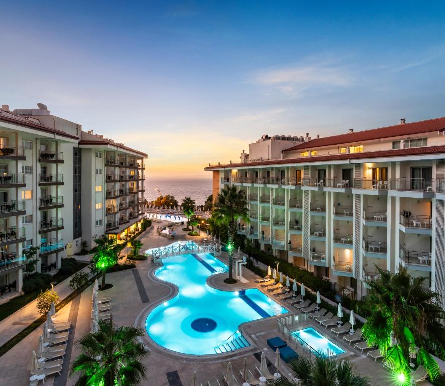 库萨达斯Ramada Hotel & Suites by Wyndham Kusadasi的享有带游泳池的度假村的空中景致