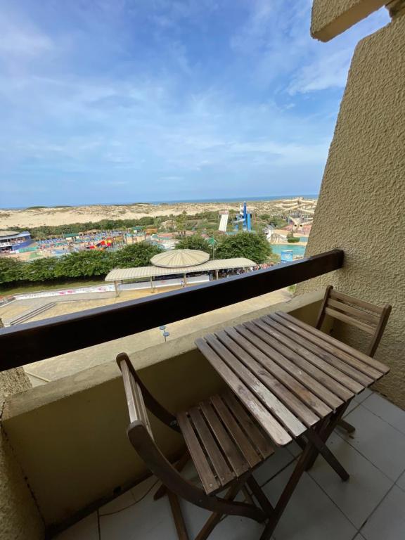 塞尼奥斯Réf 392 Seignosse océan , appartement VUE MER, proximité immédiate de la plage Idéal famille 4 personnes的木制长凳,位于阳台的顶部,享有风景。