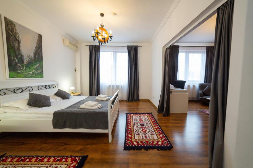 CoruncaPensiunea Koronka的卧室配有白色的床和吊灯。