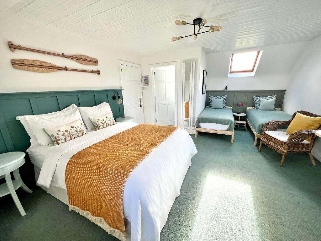 海上费萨德Thistledown Lodge的一间卧室配有一张床、一张沙发和一把椅子