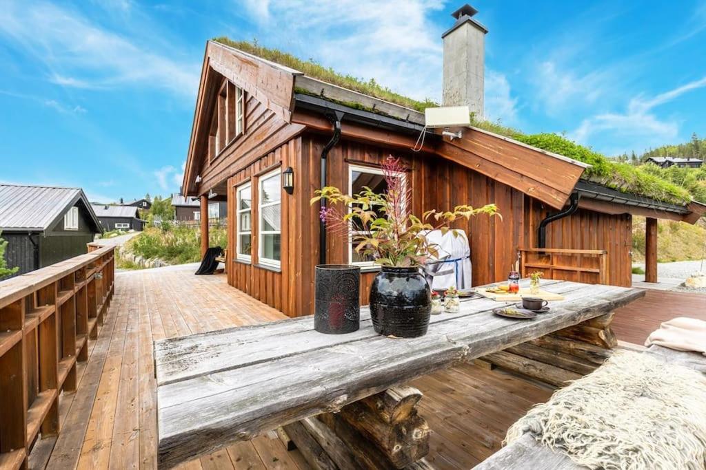 高尔Cozy cabin with sauna, ski tracks and golf outside的一座带木甲板的小木房子