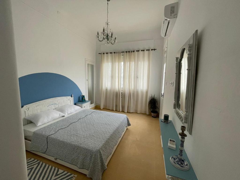 突尼斯Nomads Hostel Tunisia的一间卧室配有一张带蓝色床头板和镜子的床