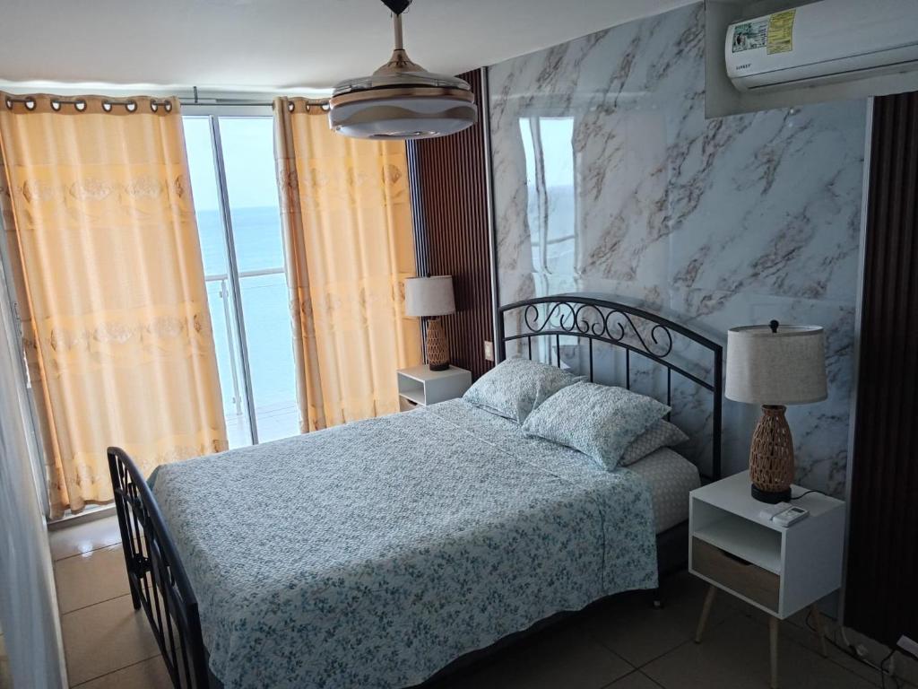 Las PalmerasEl Palmar Beach Residences 901 Beach Front View的一间卧室设有一张床和一个大窗户