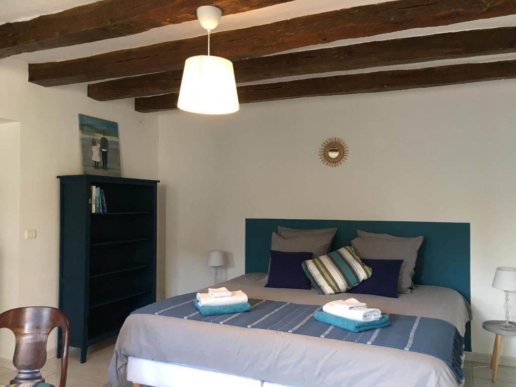 La Croix-en-TouraineLa Fedrie的一间卧室配有一张床,上面有两条毛巾