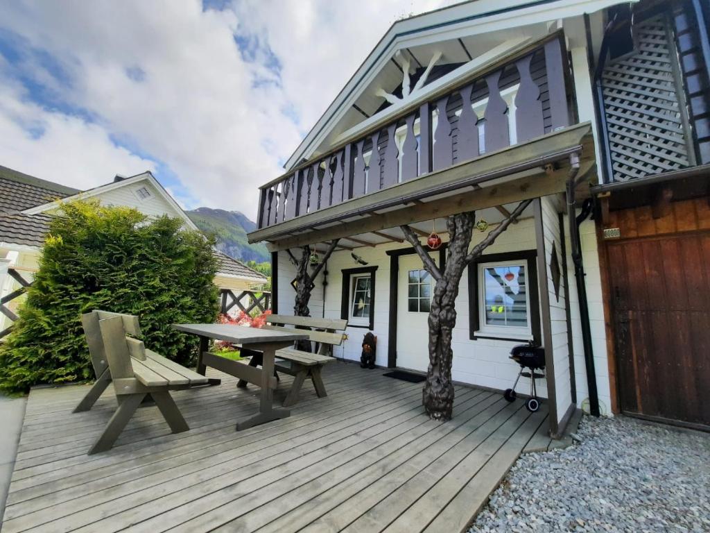 InnfjordenFjordgaestehaus的木甲板上设有野餐桌和房屋