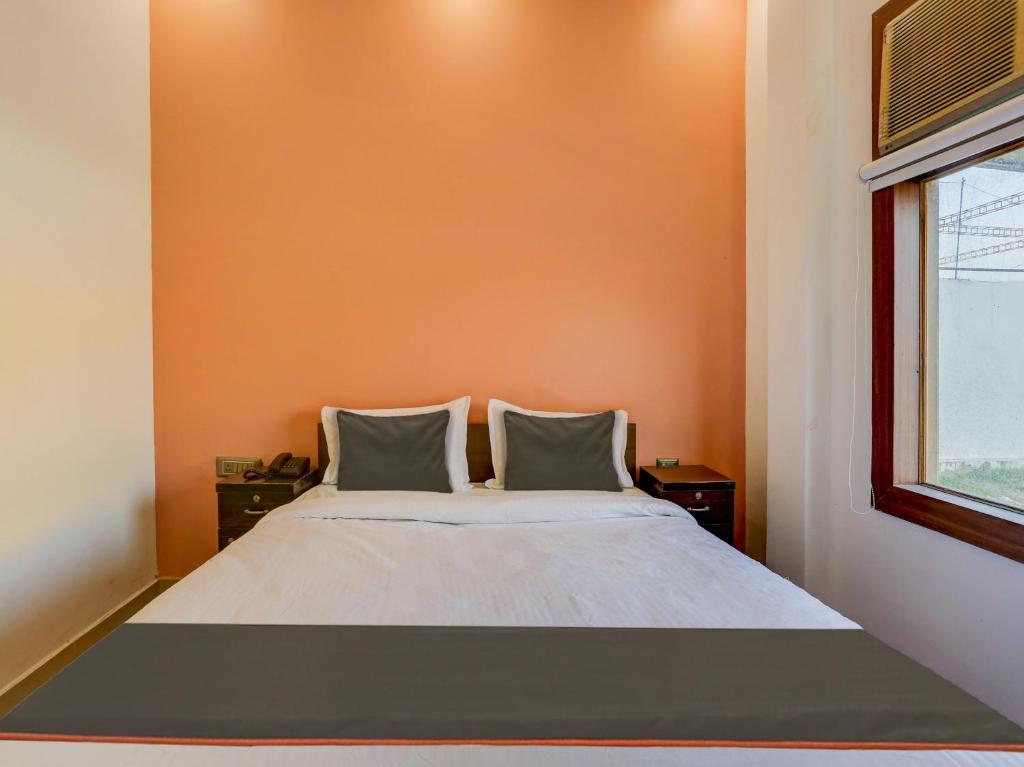 勒克瑙North Hotel & Lawn的橙色墙壁间的一张床位