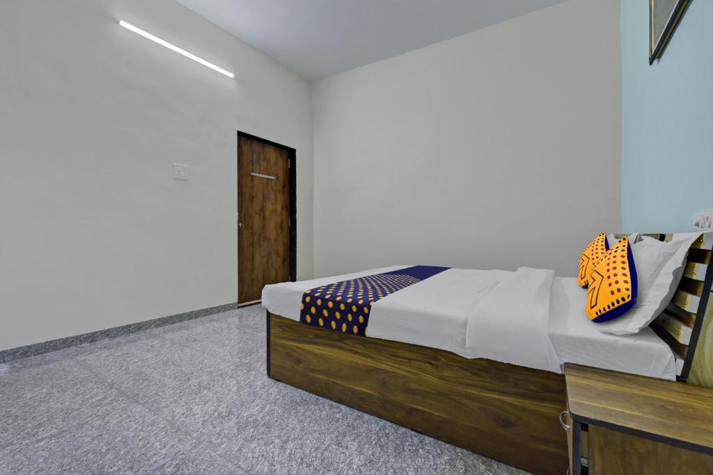 贡珀尔格尔SPOT ON Shree Murti Nandan的一间卧室配有一张床和一个木制梳妆台