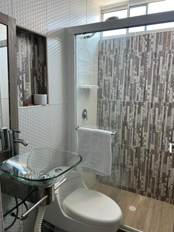 巴兰基亚Hotel Sun Suite的一间带玻璃桌和淋浴的浴室