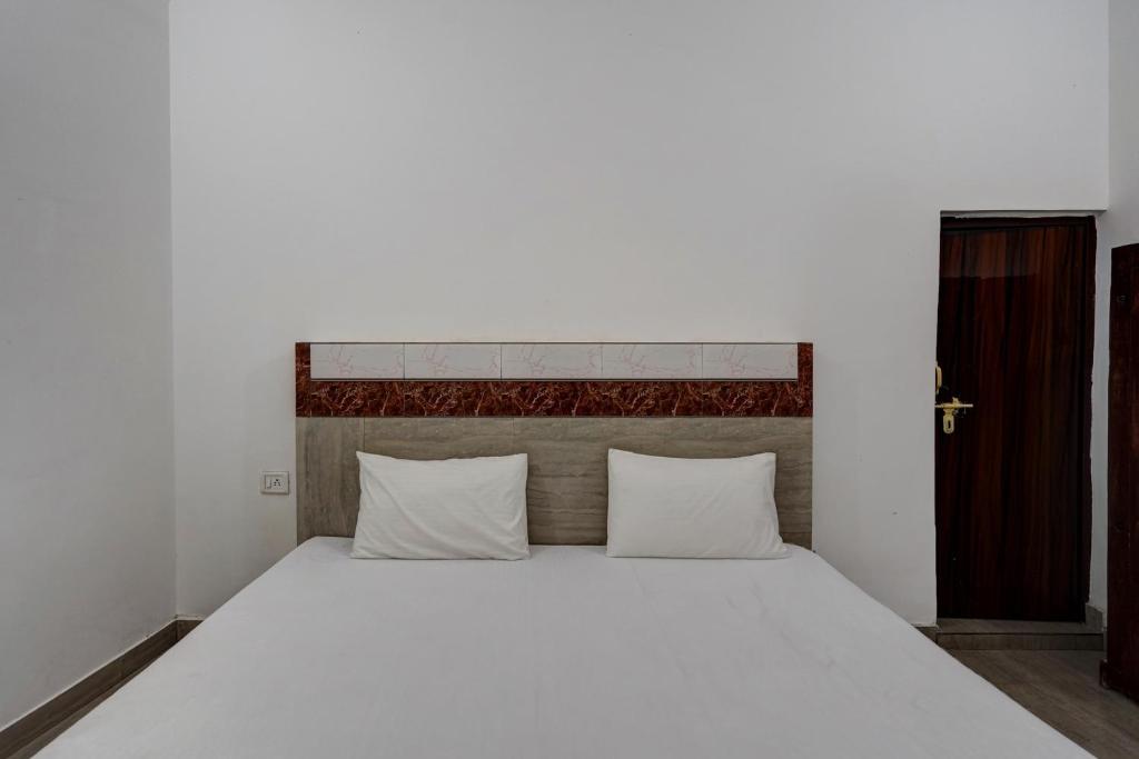 加济阿巴德OYO Sky Line的卧室配有白色大床和白色枕头