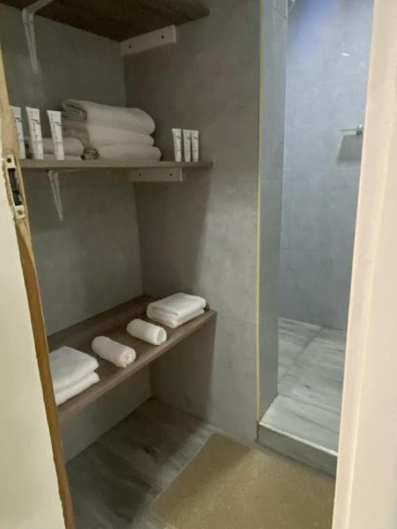 卢萨卡White House Residences的步入式淋浴间,配有毛巾和玻璃门