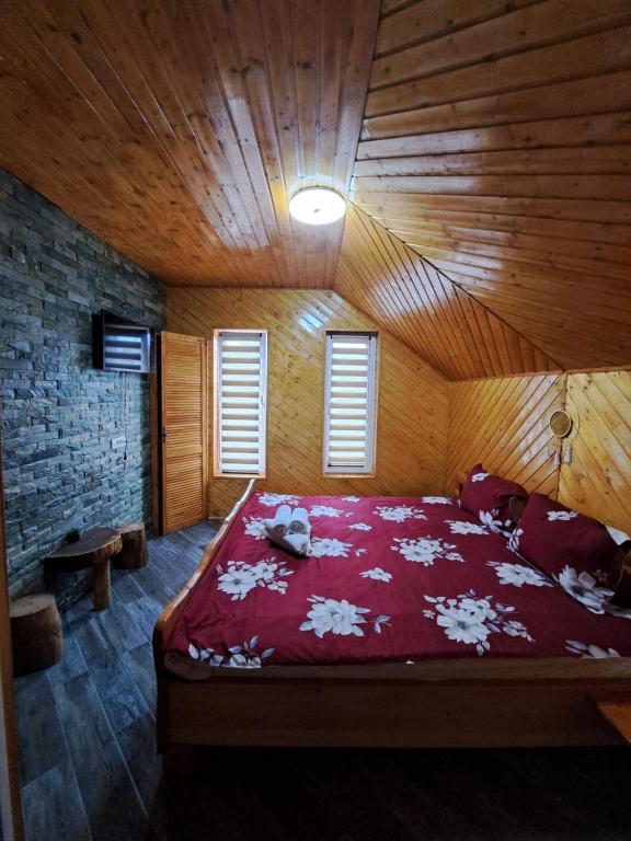 Gladna RomînăPensiunea Casa Amy的木制客房内的一间卧室配有一张大床
