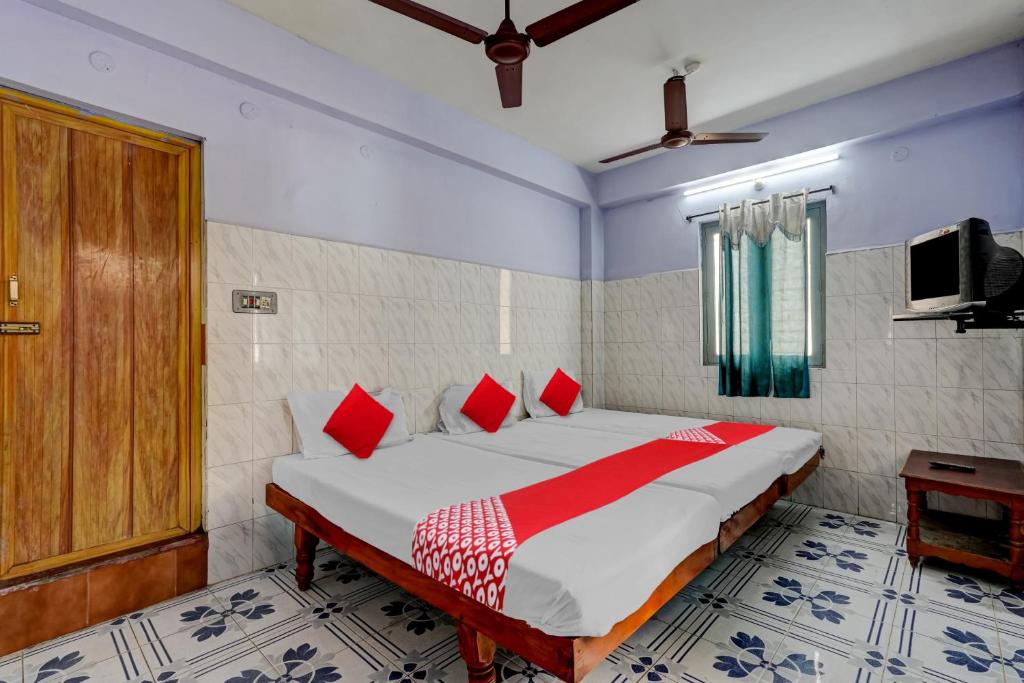 蒂鲁帕蒂OYO Flagship Sai Ganesh Deluxe Lodge的一间卧室配有一张带红色枕头的大床