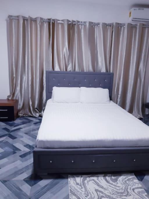 特马Lovely 1-bedroom Unit的一张带白色床单和枕头的床