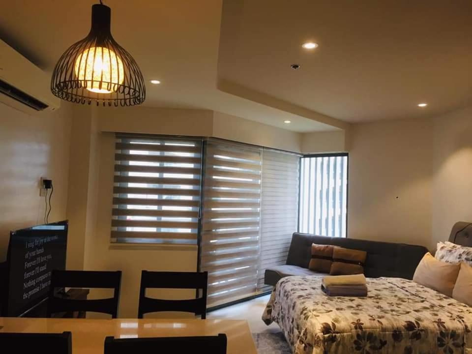 Lapu Lapu CityTambuli maribago seaside living and resort的一间卧室配有一张床、一张沙发和一张桌子