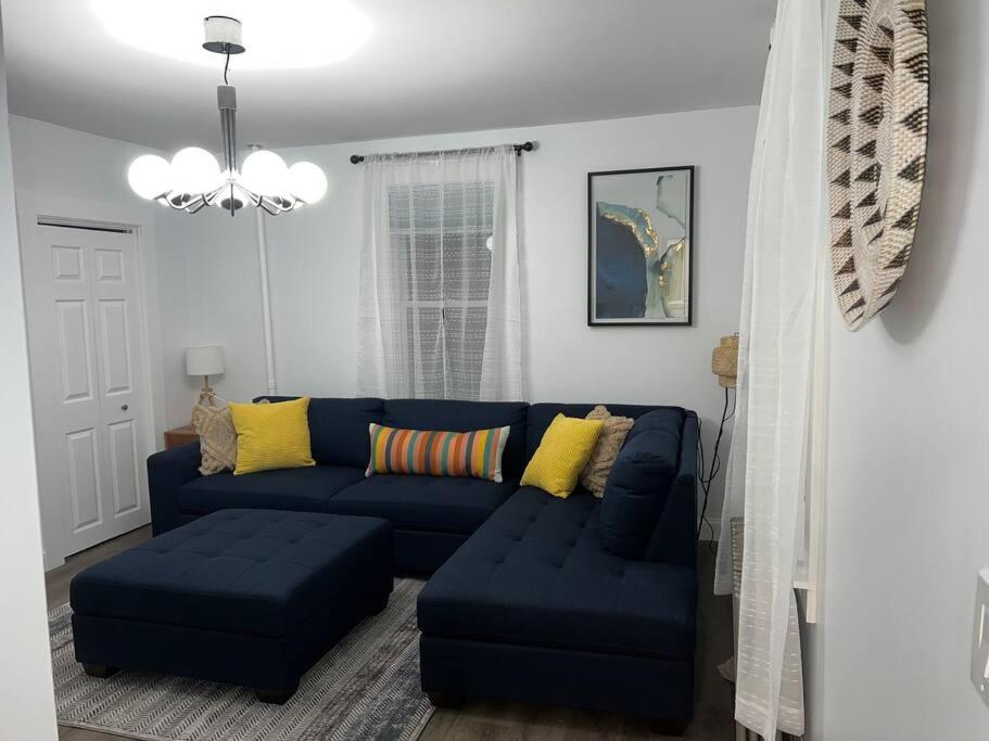 沃特敦Charming 3BR, 1BA Near Heart of Boston!的客厅配有蓝色的沙发和黄色的枕头。