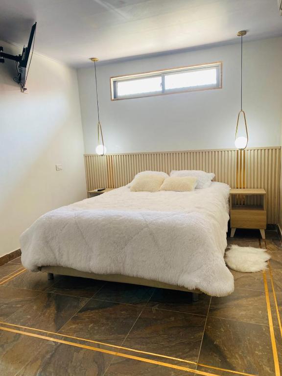 TurbacoApartaestudio Turbaco的卧室配有一张带两个枕头的大白色床