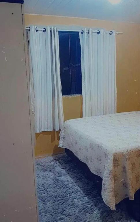 瓜拉普阿瓦Ap mobiliado的一间卧室配有床和带窗帘的窗户