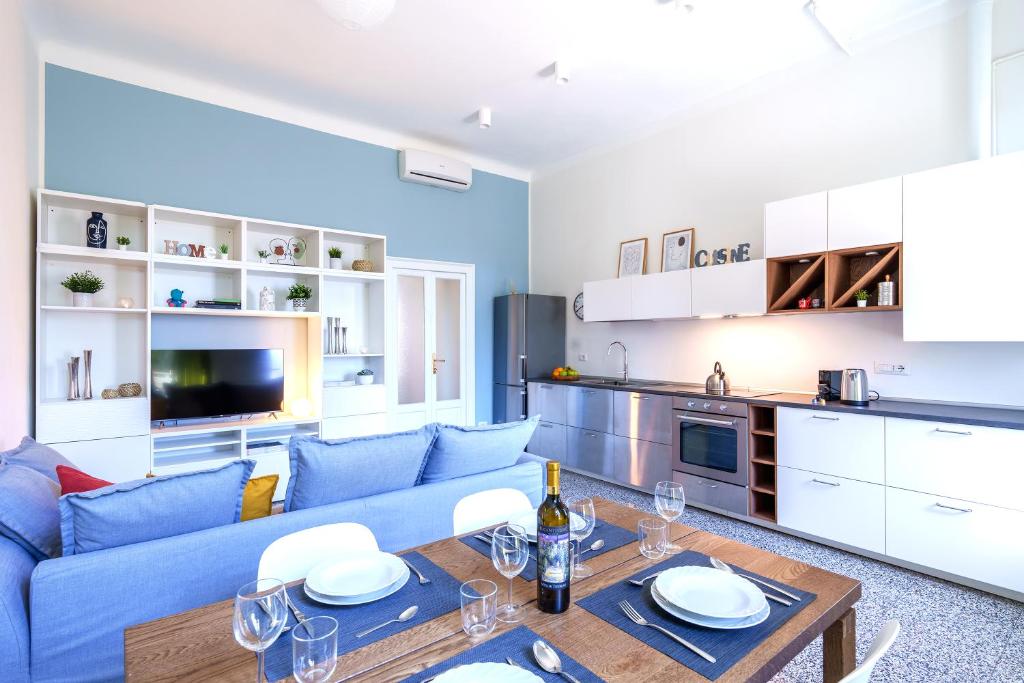 米兰[Duomo/Navigli] Casa Elegante in zona Tortona的客厅配有蓝色的沙发和桌子