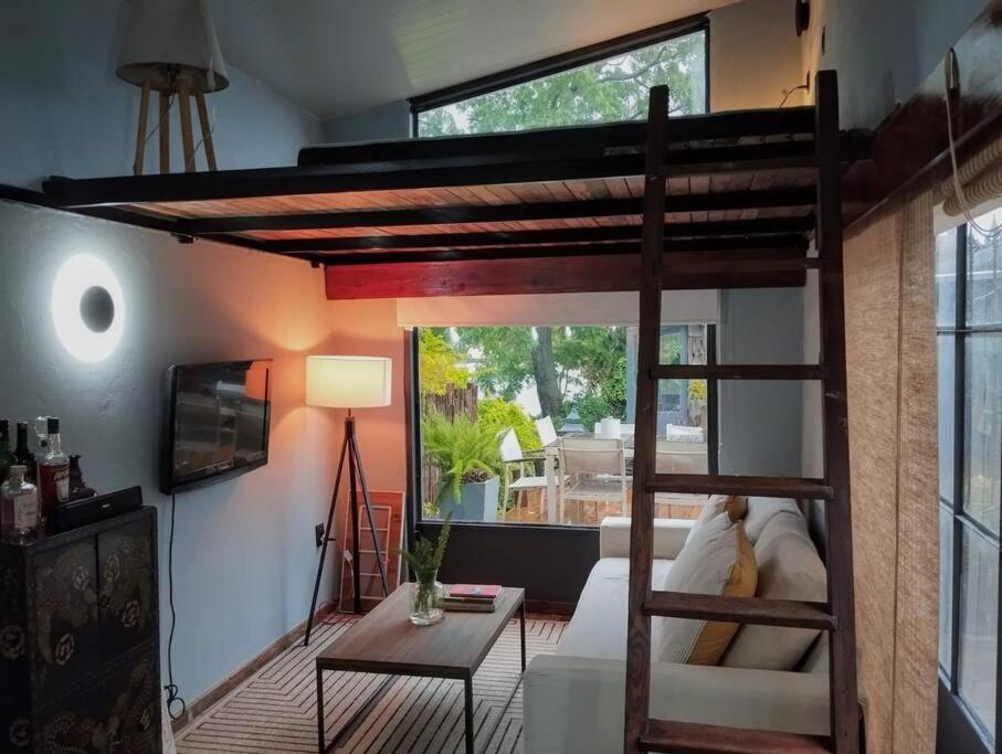 蒙得维的亚Guest Tiny House - lake side的带高架床的房间和客厅
