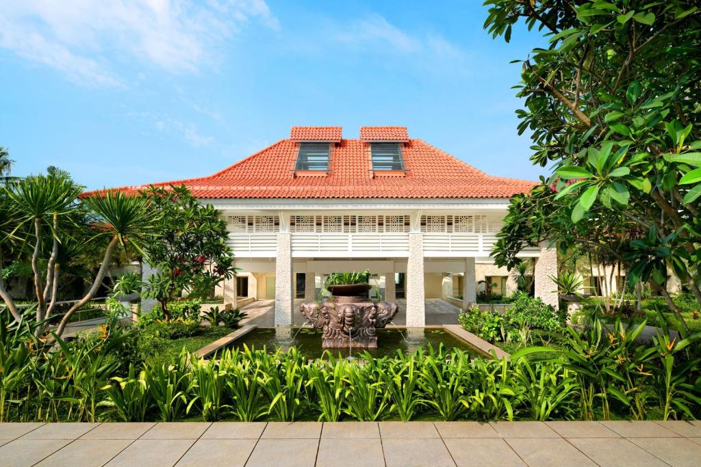 当格浪雅高酒店集团管理的班达拉国际酒店的一座大型白色房屋,设有红色屋顶