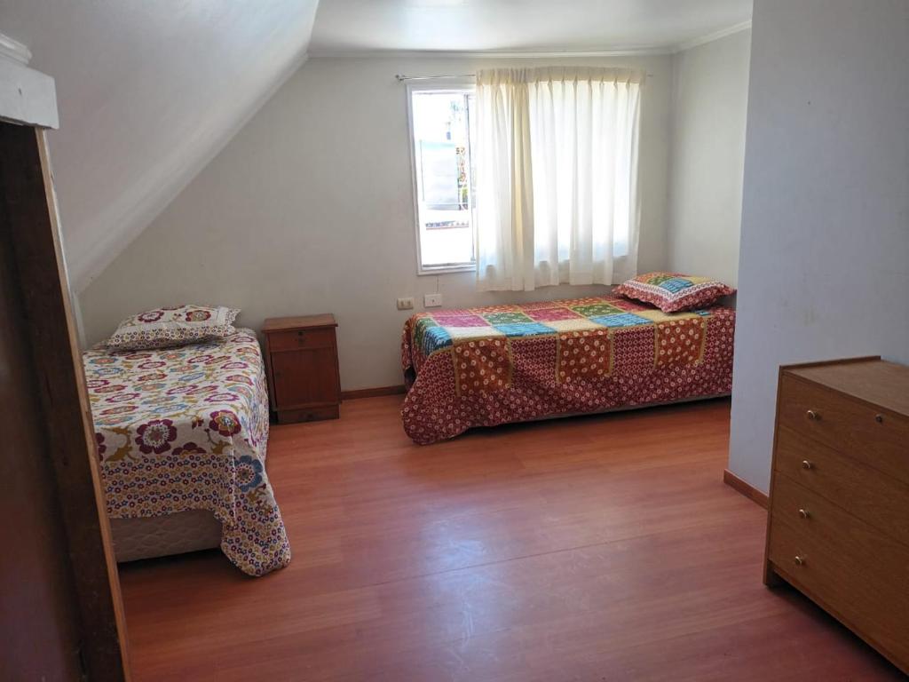 奇廉Hospedaje JM的一间卧室设有两张床和窗户。