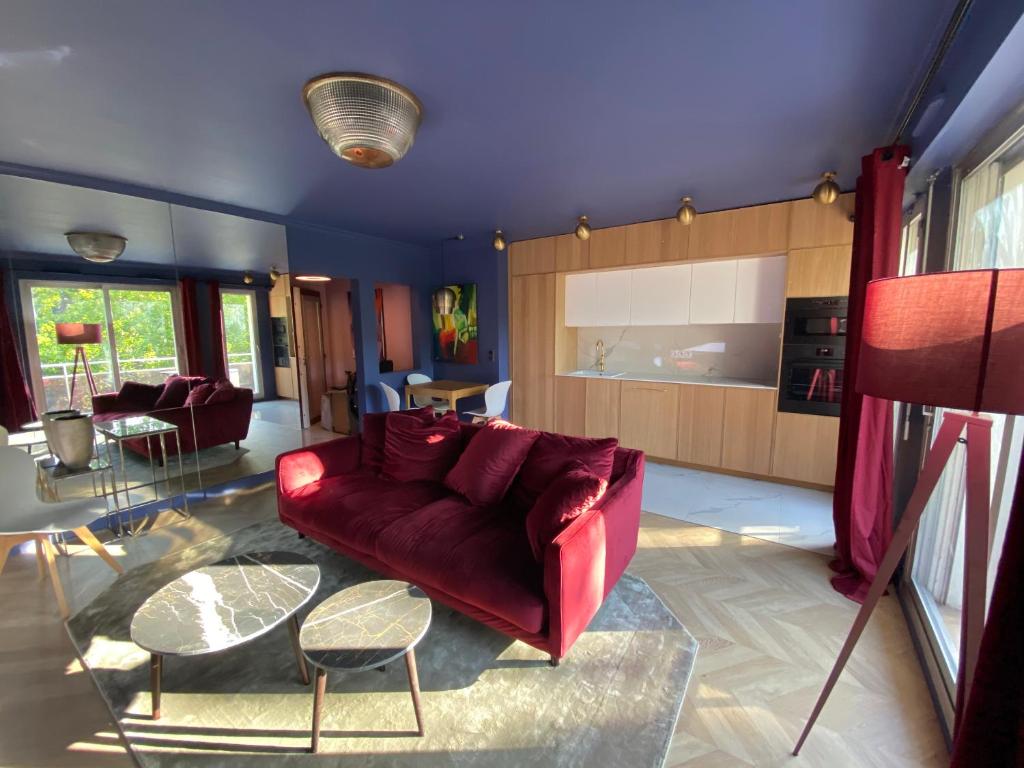 巴黎luxury Paris La Vie En Rose jacuzzi terrasse Parking的客厅配有红色的沙发和桌子