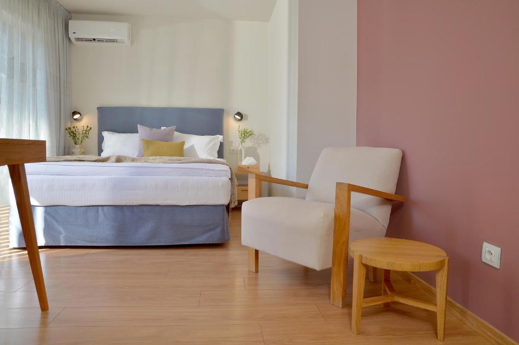 雅典Mirivili Rooms & Suites的一间卧室配有一张床和一把椅子