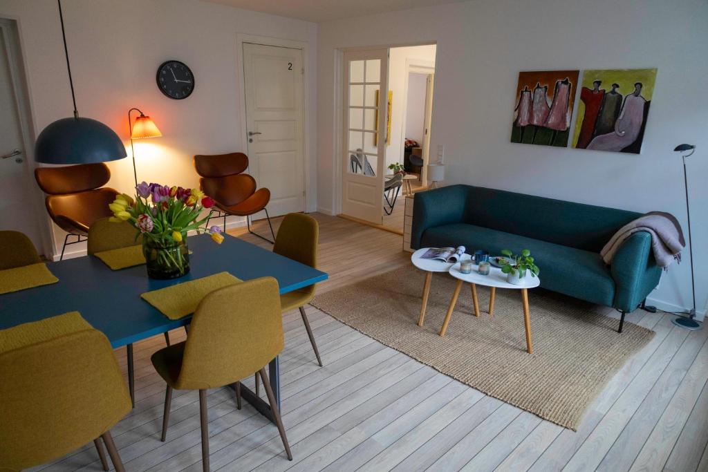 斯文堡Hyggelig byhus i stueplan med solrig gårdhave的客厅配有蓝色的沙发和桌子