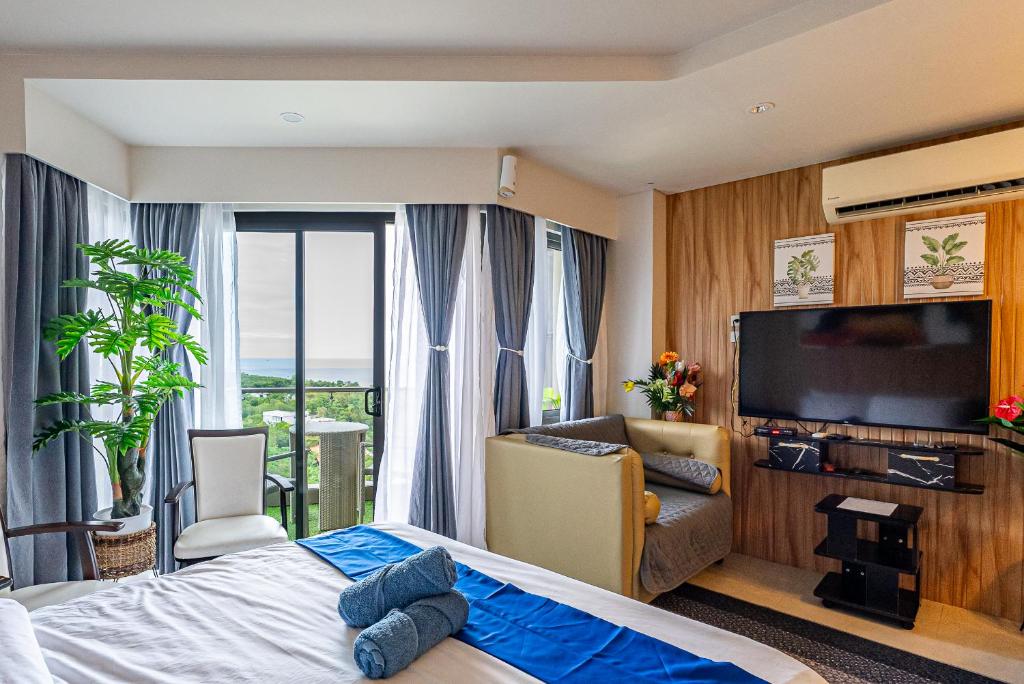 Lapu Lapu City14DC Tambuli Seaside Living的配有一张床和一台平面电视的酒店客房