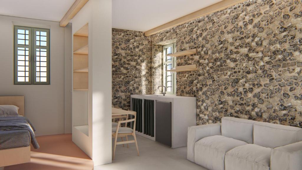 斯基亚索斯镇Capella Poulia's Home, Skiathos的一间设有砖墙、沙发和桌子的房间