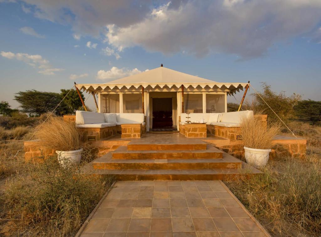 斋沙默尔Desert Camps Heritage Jaisalmer的凉亭,带长椅和桌子