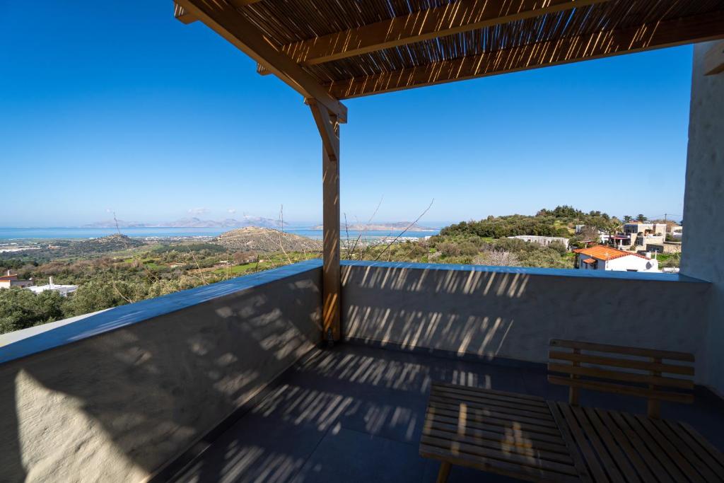 Lagoúdi ZíaVilla Rosa - Luxury Villas with Panoramic Views的阳台享有房屋美景,设有长凳