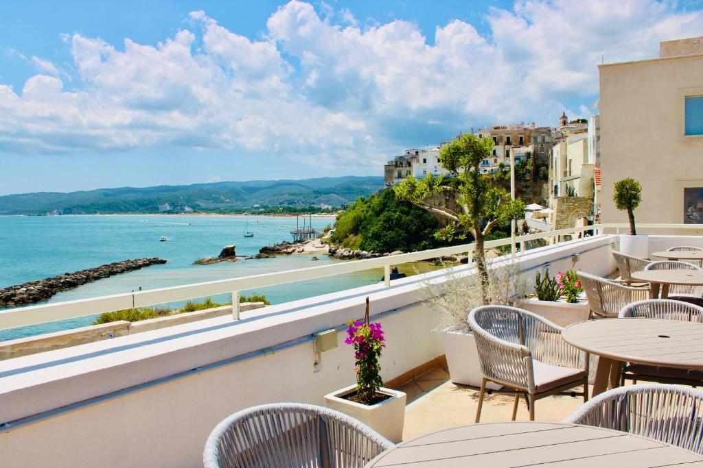 维耶斯泰Hotel Punta San Francesco的阳台配有桌椅,享有海景。