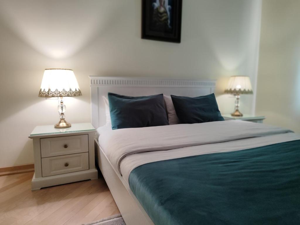 库塔伊西Crown Hotel的一间卧室配有一张床,床头柜上配有两盏灯